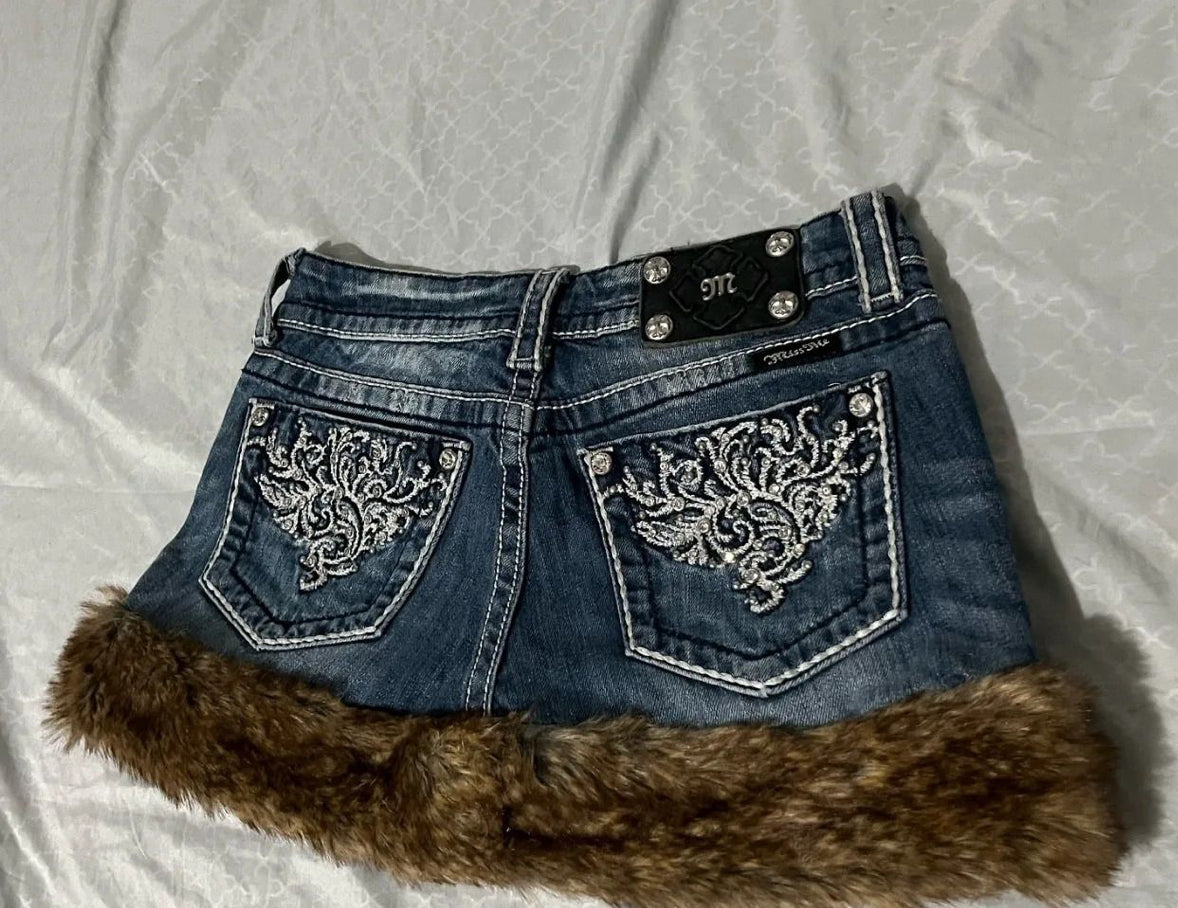 Blue denim shorts with fur trim on a white background